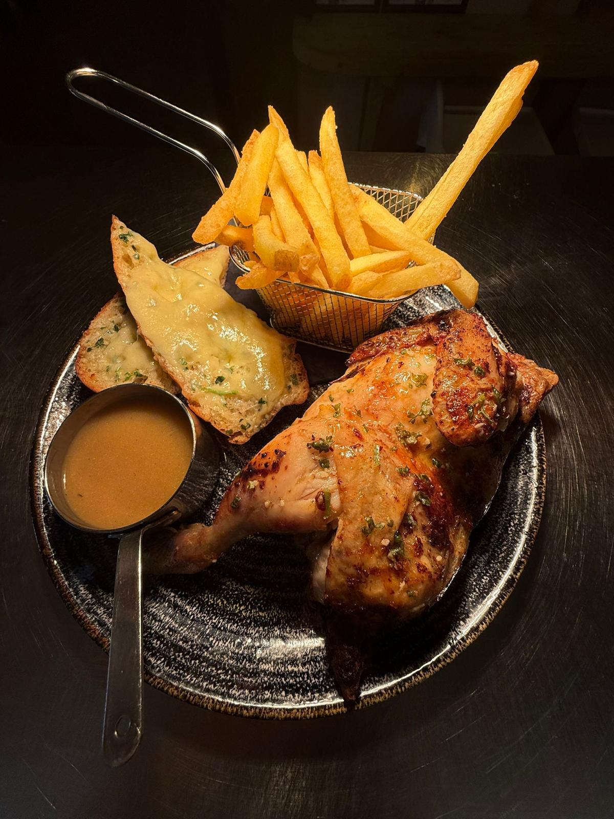 Rotisserie chicken served with chips, garlic bread and gravy at Jan'z